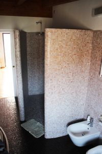 Zona living mansarda bagno con mosaico doccia su misura archtietto Pozzoli Marco